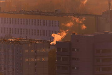 Evening view of the city. Sunset orange sky and beautiful cityscape, buildings and city streets,...