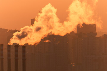 Evening view of the city. Sunset orange sky and beautiful cityscape, buildings and city streets,...