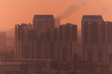 Evening view of the city. Sunset orange sky and beautiful cityscape, buildings and city streets,...