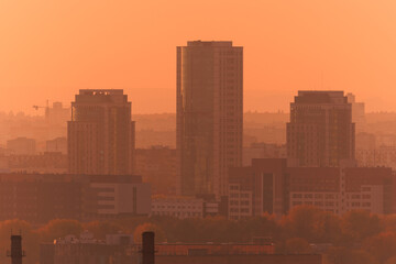 Evening view of the city. Sunset orange sky and beautiful cityscape, buildings and city streets,...