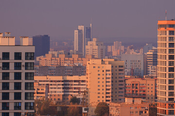 Evening view of the city. Sunset orange sky and beautiful cityscape, buildings and city streets,...