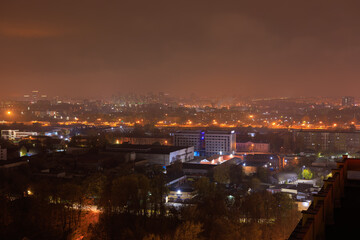 Naklejka premium Top view of the night city, lights of lamps and cars in the dark