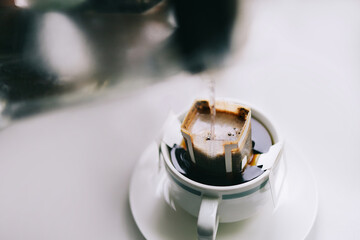  make a drip of coffee in a cup close