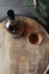 A bottle of whiskey, glass and an old wooden barrel. With copy space. 