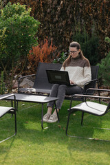 Woman working with a laptop in the backyard