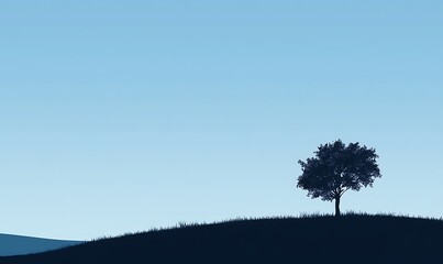Fototapeta premium A solitary tree on a hill under a clear blue sky, evoking tranquility and nature's beauty.