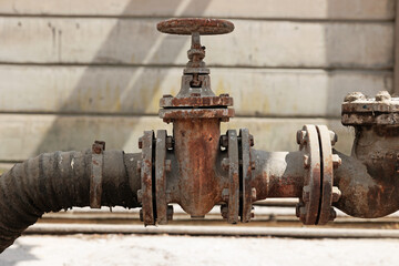 dettaglio di una valvola su una grossa tubatura per la regolazione del flusso di liquidi industriali, all'aperto, di giorno