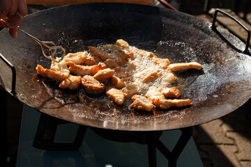 Frying fish cracklings in an outdoor pan