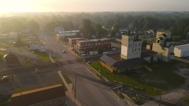 Carleton, USA - Small town railway crossing with industrial and residential buildings at sunrise