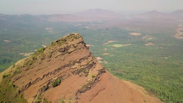 Drone view of Chikmagalur mountain peak showcasing rugged terrain and lush valley below