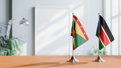 FLAGS OF GRENADA AND SOUTH SUDAN ON TABLE