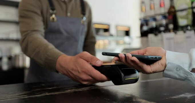 Close up in the cafe man makes takeaway coffee for a customer who pays by contactless mobile phone to credit card system in cafe with digital transaction service. - Powered by Adobe