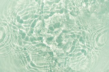 Fototapeta premium Blue water with ripples on the surface. Defocus blurred transparent blue colored clear calm water surface texture with splashes and bubbles. Water waves with shining pattern texture background.