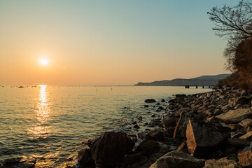 vista panoramica del sole che tramonta sul Mare Adriatico, visto dalla costa sul Golfo di Trieste,...