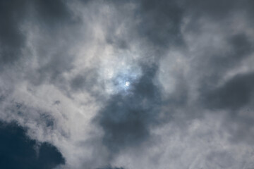 disco solare o sagoma chiara del sole visto durante il giorno da dietro le nuvole nel cielo