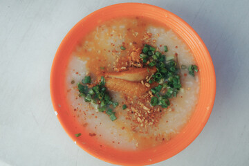 Arroz Caldo, a Philippine street food made of rice and chicken gruel with ginger, toasted garlic, scallions, and pepper.