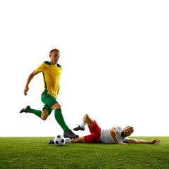 Two players facing off in intense moment of soccer game on green grass of football field, focusing...