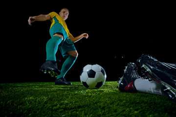 Naklejka premium Close-up of soccer ball with two players converging in dynamic moment on field. Bombardier opponent of goalkeeper. Concept of sport event, championship, motion, match, energetic game. Ad