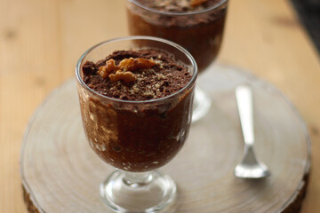 Two bowls of chia seed, chocolate and orange pudding. Healthy snack, wooden background. Selective focus.
