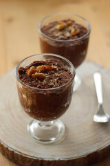 Two bowls of chia seed, chocolate and orange pudding. Healthy snack, wooden background. Selective focus.
