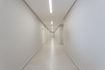 Corredor hospitalar, com paredes e portas brancas