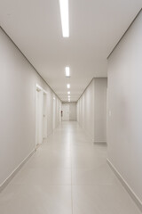 Corredor hospitalar, com paredes e portas brancas