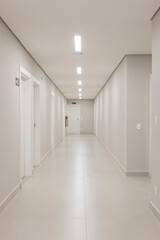 Corredor hospitalar, com paredes e portas brancas