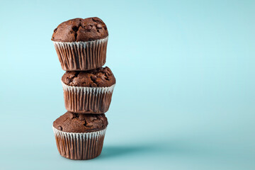 Pile of chocolate chip muffins on blue background.