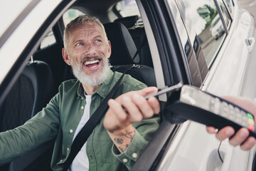 Photo of attractive funny retired guy wear khaki shirt riding automobile paying cafe to go outdoors...