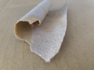 A close-up of baking ingredients with a roll of paper and a white chocolate cake