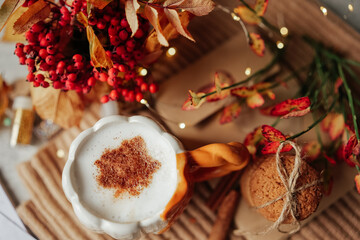 Autumn composition of spice Latte, cookies and fall leaves on the table.