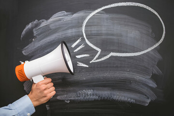 Hand with megaphone points to chalkboard with empty speech bubble