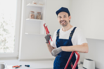 Friendly handyman with wrench ready for home renovation in kitchen setting