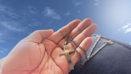 Brown wooden cross holding in hand, symbolizing, recalling and spreading of Jesus Christs love to all Christians