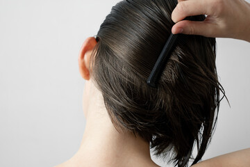 Naklejka premium Brushing wet hair with comb for healthy care