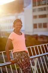 Happy, portrait or black woman with headphones for fitness, music or audio streaming in city. Young African, female person or runner with smile for radio, workout podcast or exercise in an urban town