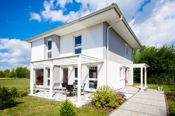 Weißes Einfamilienhaus mit Garten