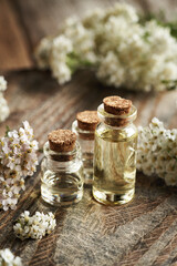 Three bottles of aromatherapy essential oil with fresh yarrow