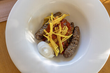 Mirada meatballs, grated and cooked potatoes, served with tomato sauce.