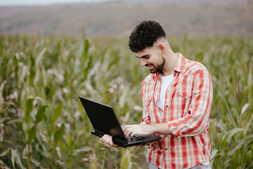 Young Man Using Laptop in Cornfield