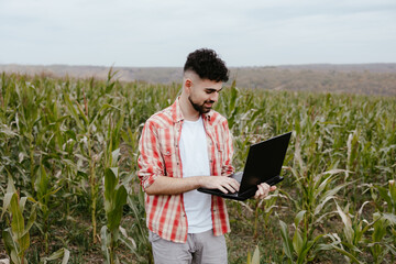 Young Farmer with Laptop in Cornfield