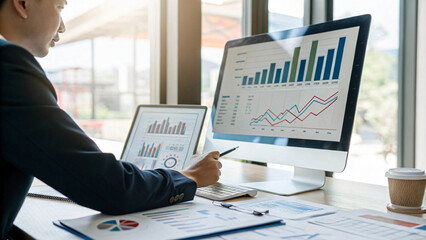 business professional analyzing data on computer screens in office setting, showcasing graphs and charts. atmosphere is focused and productive
