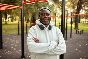 Portrait of a senior man exercising at outdoor fitness park in autumn