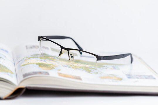 Glasses resting on open book, symbolizing relaxation after intense research and study. Ideal for concepts of learning, focus, academic work, and intellectual breaks