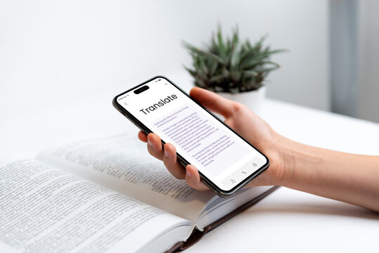 Phone in hand displaying book translation app with OCR scanning concept. Ideal for themes of language learning, translation technology, reading, and digital education