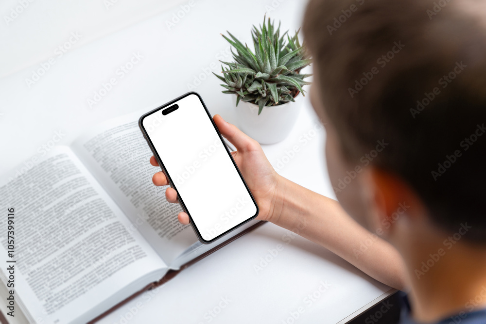 Poster child holding phone beside a book, isolated screen display ideal for mockups and app presentations. 