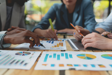 Obraz premium Hands business team having a meeting to analyze data graph charts for a marketing plan in the office