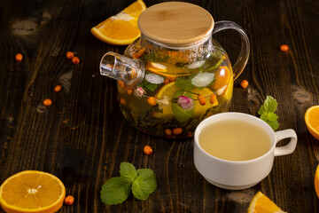 tea with orange and ripe sea buckthorn berries