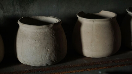 Clay Cups Neatly Arranged on Wall Shelf in Antique Kitchen