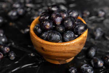 fresh grapes are lying on black paper